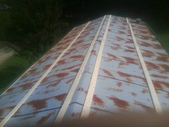 Rusted metal roof panels with new wood purlins before replacement — Storm Damage Roof Repair in Polson by Roofing Brothers